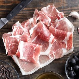 Slices of Serrano ham on wooden board - The Iberians